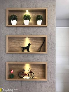 three wooden shelves with plants and toys in them on the wall next to each other