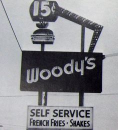 a black and white photo of a sign that says woody's self service french fries shakes