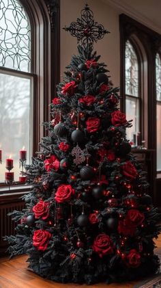 a black and red christmas tree with roses on the top is in front of a window