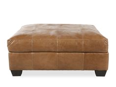 a brown leather ottoman with black legs