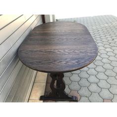 a wooden table sitting on top of a sidewalk