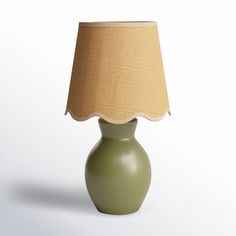 a green lamp with a beige shade on it