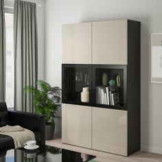 a black and white cabinet in a living room with a couch, coffee table and potted plant