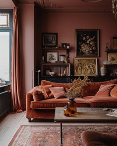 a living room filled with furniture and a painting on the wall next to a window