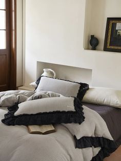 an unmade bed with black and white pillows