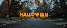 the words halloween are displayed in front of an empty road