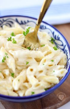 a blue and white bowl filled with macaroni and cheese