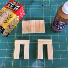 two pieces of wood sitting on top of a cutting board next to glue and some other items