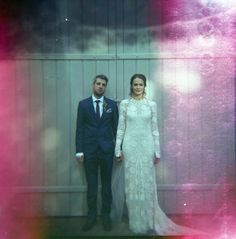 a man and woman standing next to each other in front of a door wearing formal attire