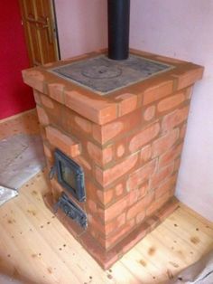 a brick stove sitting on top of a hard wood floor