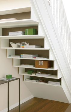 a staircase with bookshelves and shelves under the bannister in a home