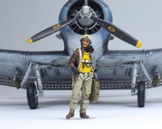 a toy pilot standing in front of an airplane