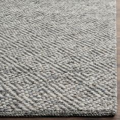 a gray rug on top of a wooden floor