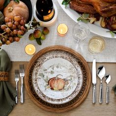 a table set for thanksgiving dinner with silverware, candles and turkeys on it