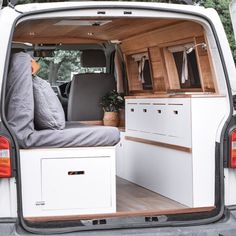 the interior of a white van with drawers and storage compartments on the rear door area