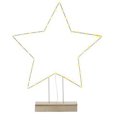 a white star with yellow lights on it and a wooden stand in front of it