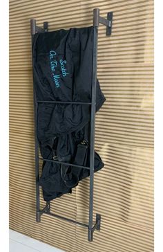 an umbrella is hanging on the wall next to a coat rack with two coats in it