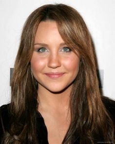 a close up of a person with long hair and blue eyes smiling at the camera