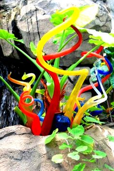 there are many colorful glass sculptures on the rocks