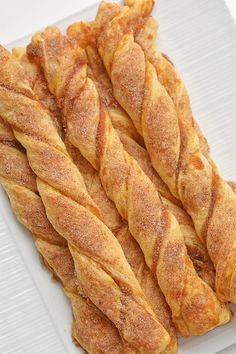 some very tasty looking bread sticks on a white plate with sugar sprinkles