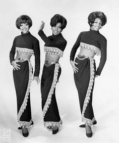 three women in black and white outfits posing for the camera with their hands on their hips