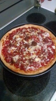 a pizza sitting on top of a stove next to an oven