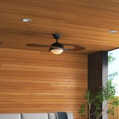 a living room with wooden walls and ceiling fans