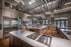 a large kitchen with stainless steel appliances and wood flooring is pictured in this image