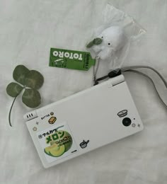 a white laptop computer sitting on top of a bed next to a green leafy plant