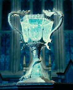 an ornate blue glass vase sitting on top of a table