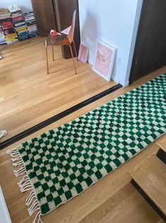 a green and white rug sitting on top of a wooden floor