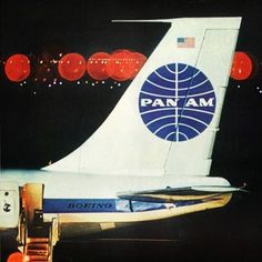 an airplane with the word pan am painted on it's side and lights in the background