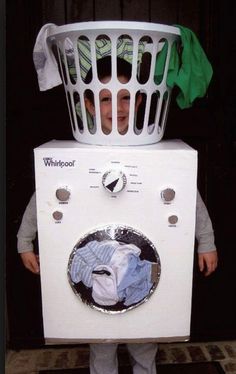 a young boy is standing in front of a washing machine with his laundry basket on top of it