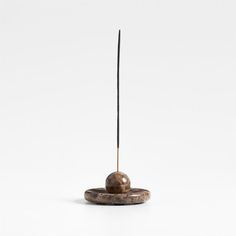 a rock with a long stick sticking out of it's center on a white background