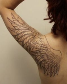 the back of a woman's shoulder with an angel wing tattoo on her left arm