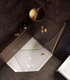 an overhead view of a bathroom with a glass shower stall and gold fixtures on the walls