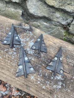 four metal airplanes are sitting on a piece of wood