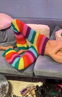 a woman laying on top of a couch wearing colorful socks