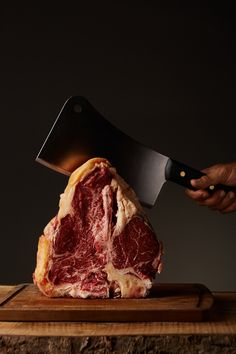 a large piece of meat being cut into pieces with a knife on top of it