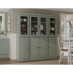 a large green cabinet with glass doors in a dining room