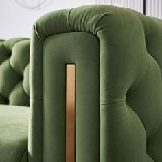 a green couch with a wooden handle on it's arm and backrests