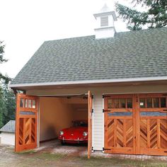 a red car is parked in the garage with two doors on it's side