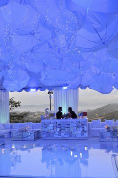 a couple sitting under an umbrella covered room