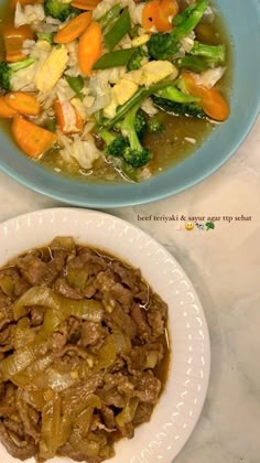 two bowls filled with food sitting on top of a table