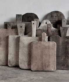 a group of wooden cutting boards sitting on top of a cement floor next to each other