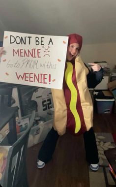 a woman in a hot dog costume holding a sign that says don't be a meanie go get from this wiener