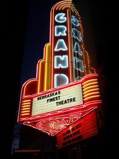 the marquee for grand theatre is lit up at night