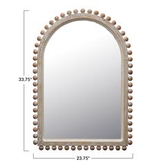 an arched mirror with beaded trim around the edges, and a wooden frame on top