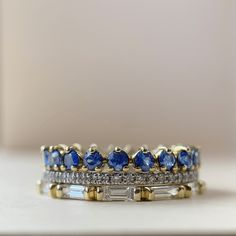 a stack of rings with blue and white stones on top of each other, sitting on a table