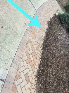 an arrow pointing to the right on a brick walkway with mulch and grass around it